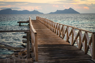 Pier on sea against sky during sunset