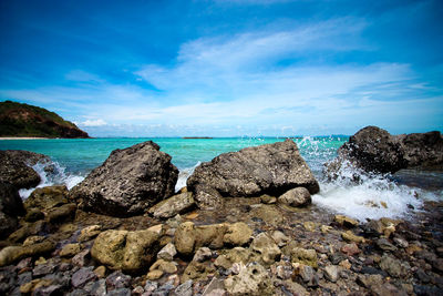 Rock formation in sea against blue sky