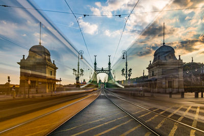 Railroad tracks amidst buildings against sky with trams