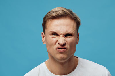 Low angle view of young man against clear blue sky