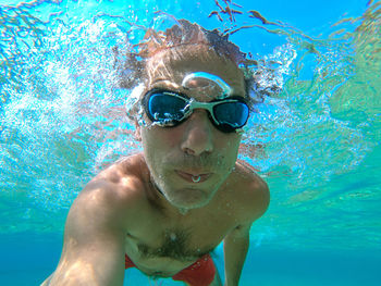 Portrait of young man swimming in pool