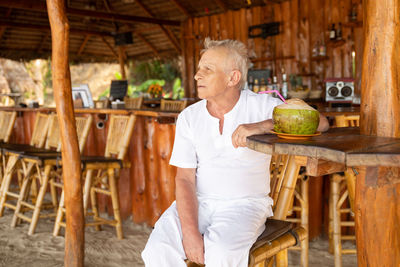 Portrait of senior man sitting on table