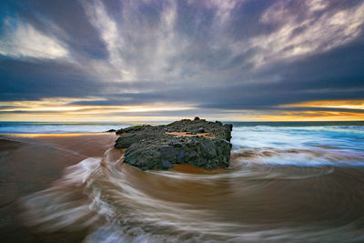 Scenic view of beach against sky during sunset