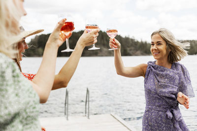 Female friends having wine on jetty