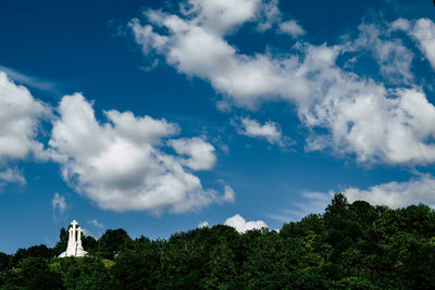 Low angle view of trees and building against sky