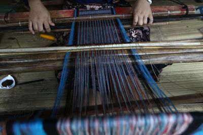 Midsection of woman weaving textile