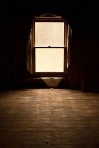 Empty wooden table in illuminated room