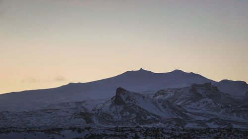 Scenic view of snowcapped mountains against sky during sunset