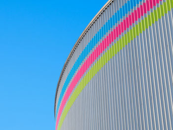 Low angle view of multi colored umbrellas against blue sky