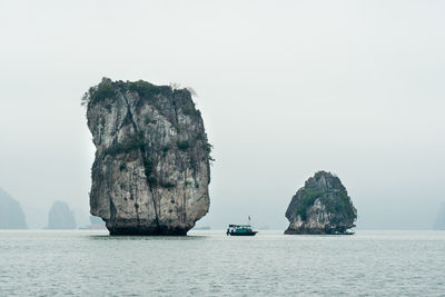 Scenic view of rock formation in sea against sky