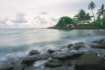 Scenic view of rocks in sea against sky