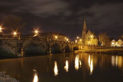 Reflection of illuminated bridge in water at night