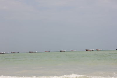 Sailboats in sea against sky