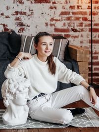 Portrait of young woman sitting on floor at home