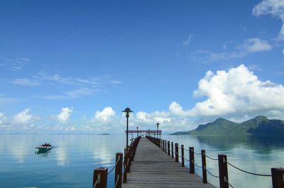 Pier over sea against blue sky