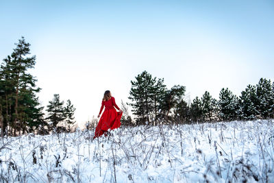 Red umbrella on field against sky during winter