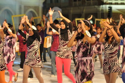 Smiling people walking on street during carnival