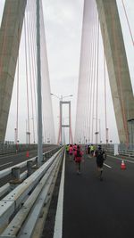 Cars on bridge in city against sky