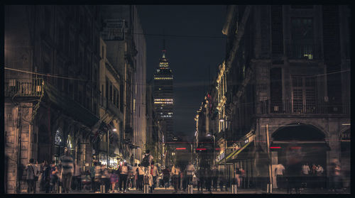 People walking on street in city at night