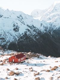 Houses by snow covered mountains against sky