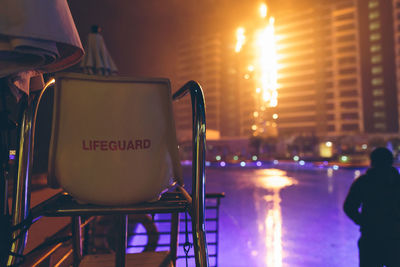 Close-up of illuminated lighting equipment in city at night