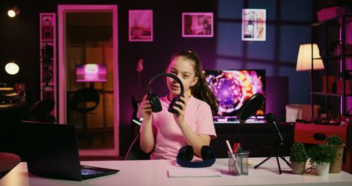 Portrait of young woman using mobile phone while sitting at home