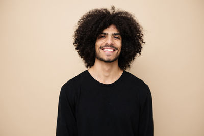 Portrait of smiling man against beige background