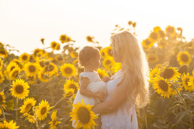 Woman with daughter in sunflower field