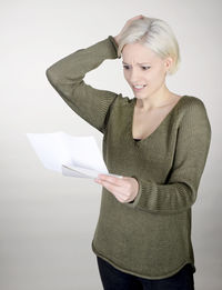 Smiling mid adult woman standing against white background