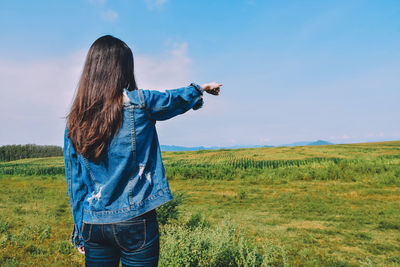 Rear view of woman standing on field