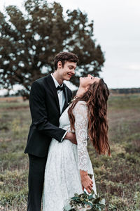 Young couple standing against plants