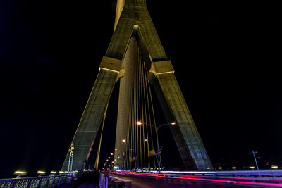 Low angle view of illuminated bridge against sky at night