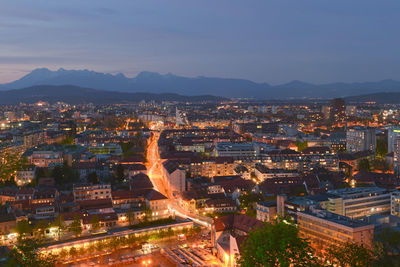 Illuminated cityscape against sky at dusk