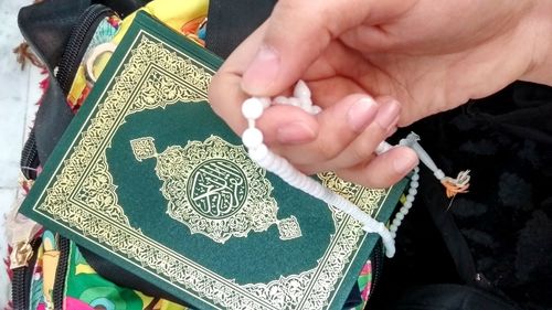 High angle view of hands holding cross