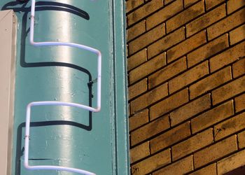 Low angle view of metallic ladder on building