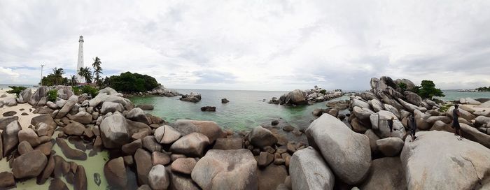 Panoramic view of rocks on beach against sky