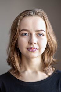 Close-up portrait of young woman against black background