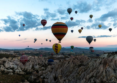 Hot air balloons flying over landscape against sky