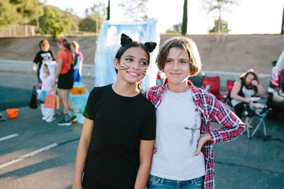 Young teen girls stand together at a halloween trunk or treat event