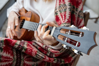 Midsection of woman playing guitar