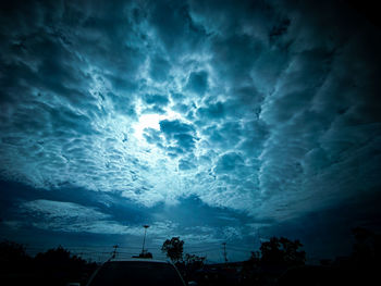 Low angle view of silhouette trees against sky