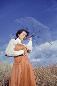 Woman standing on field against sky