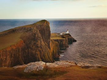 Rock formations by sea against sky