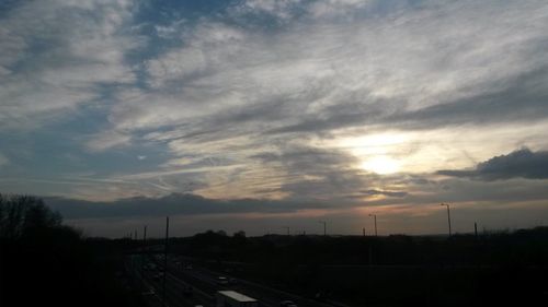 View of road against cloudy sky at sunset