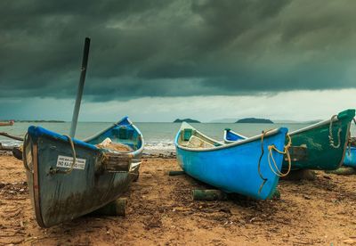 Boats moored on beach against sky