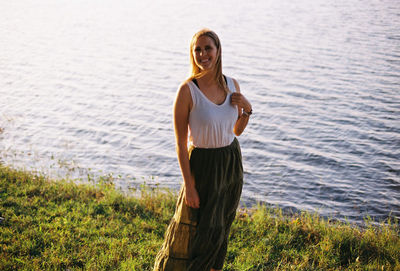 Young woman wearing sunglasses standing on shore