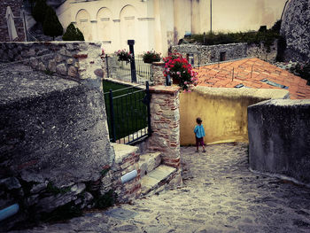 Woman standing by old building