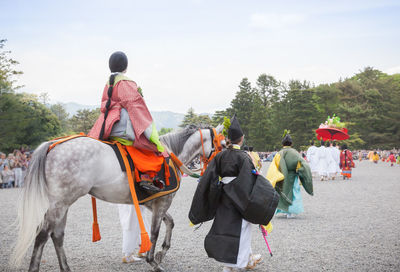 Rear view of people riding horses