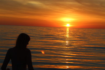 Woman looking at sea during sunset