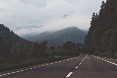 Road by mountains against sky